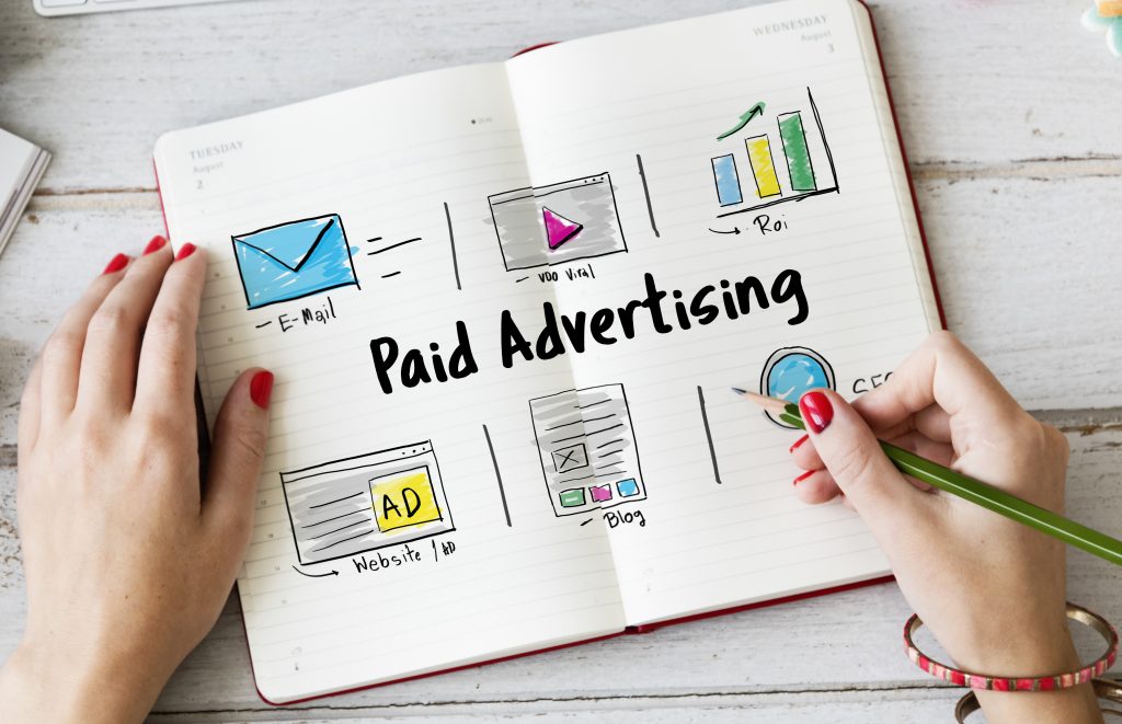 desk with a notebook and said paid advertising