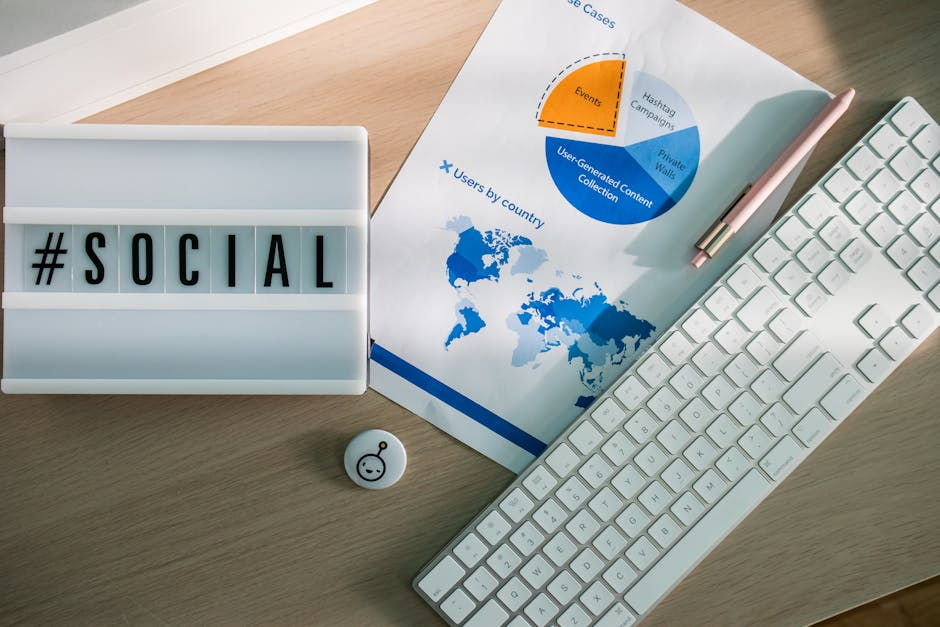 Desk with #SOCIAL sign, charts, keyboard, and pen.