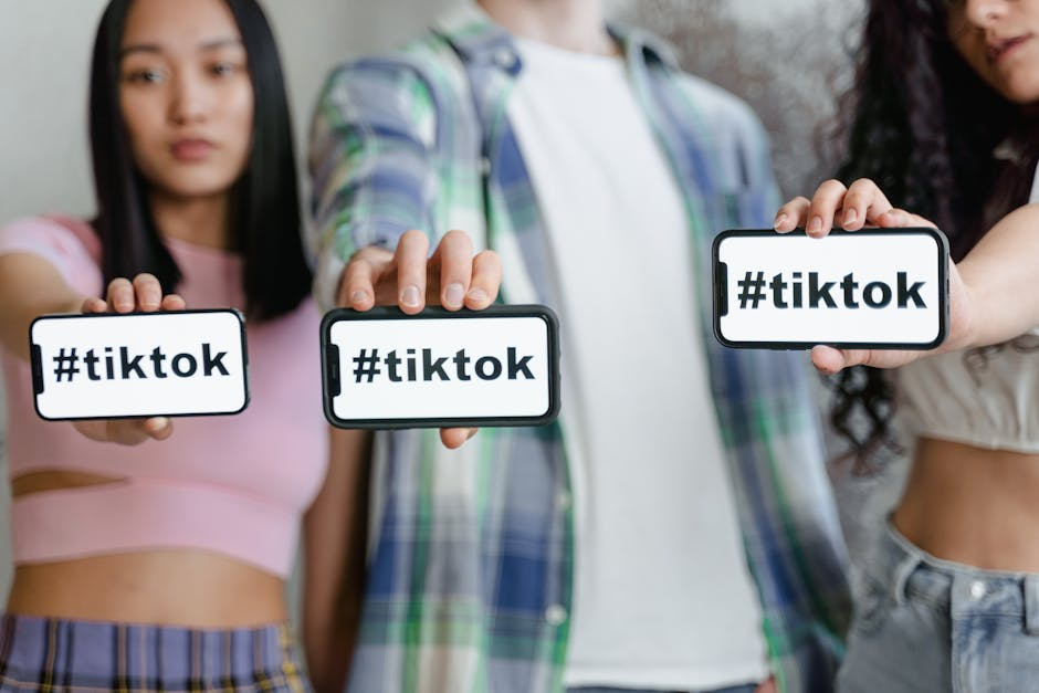 Three people holding TikTok signs.