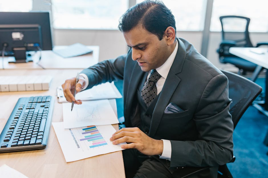 Businessman analyzing graphs at desk.
