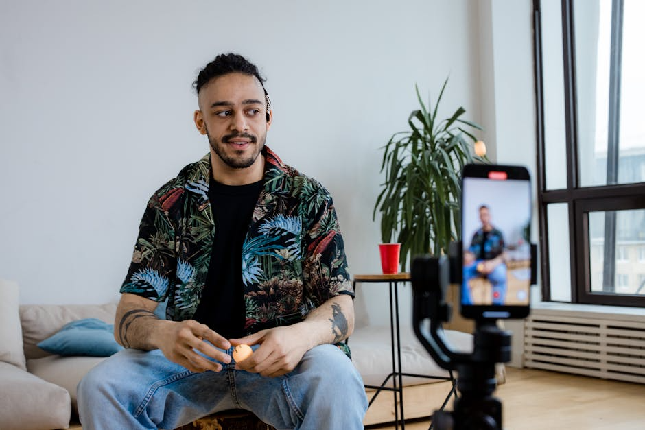Man sitting with phone recording video.